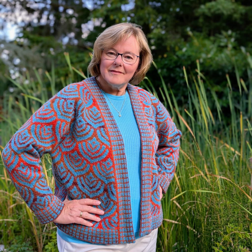 Eine Frau trägt eine Strickjacke in bunten Farben.