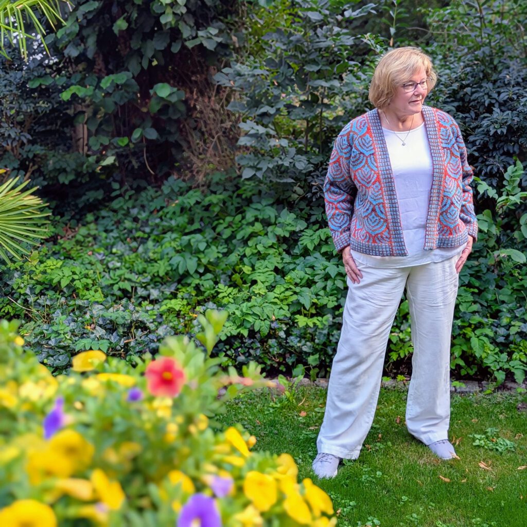 Eine Frau trägt eine Strickjacke in bunten Farben.