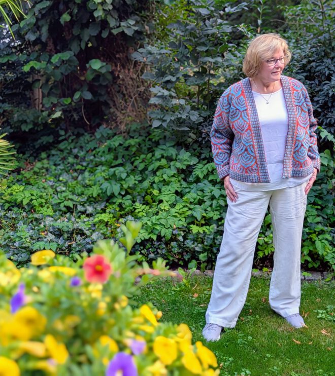 Eine Frau trägt eine Strickjacke in bunten Farben.