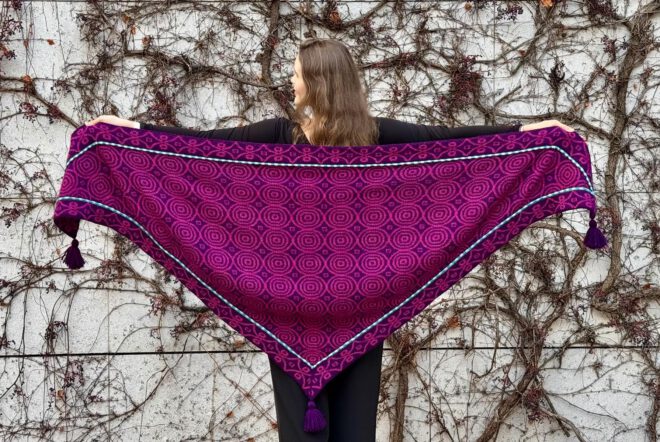 Eine Frau steht mit dem Rücken zur Kamera und zeigt ein ausgebreitetes Tuch.